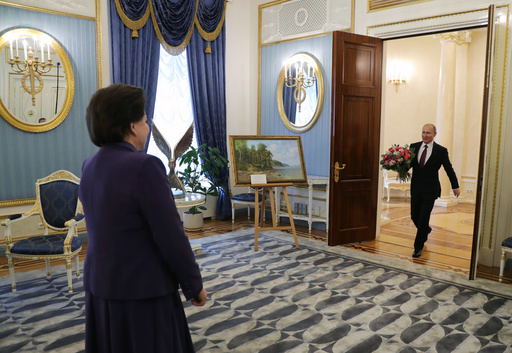 Russian President Vladimir Putin, right, carries flowers to congratulate the first woman in space, cosmonaut Valentina Tereshkova, on her 80th birthday in Moscow, Russia, Monday, March 6, 2017. (Alexei Nikolsky/Sputnik, Kremlin Pool Photo via AP)